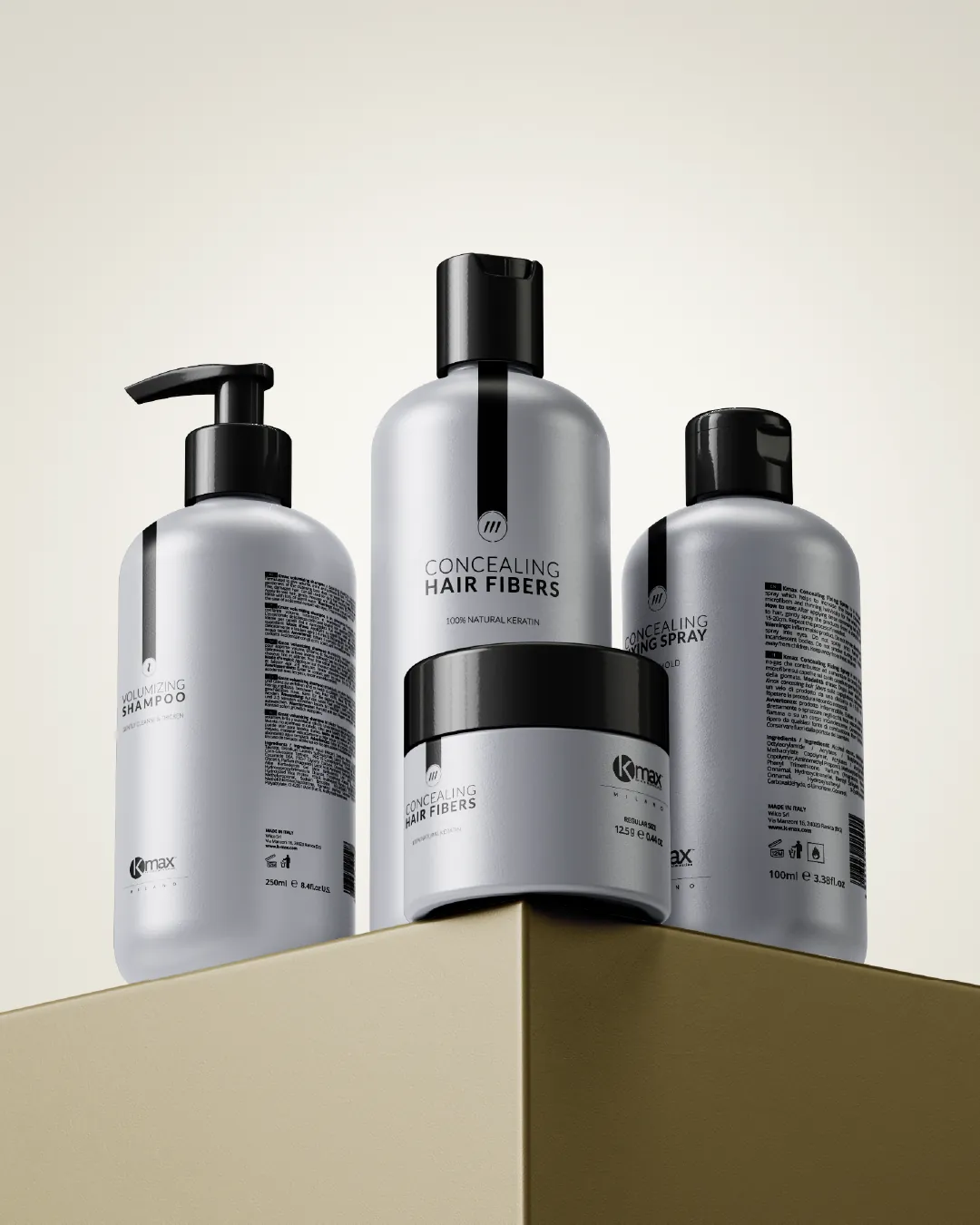 Quatre emballages gris aux bouchons noirs sur un socle doré : un shampoing avec pompe, un flacon Concealing Hair Fibers, un pot et un flacon Concealing Fixing Spray